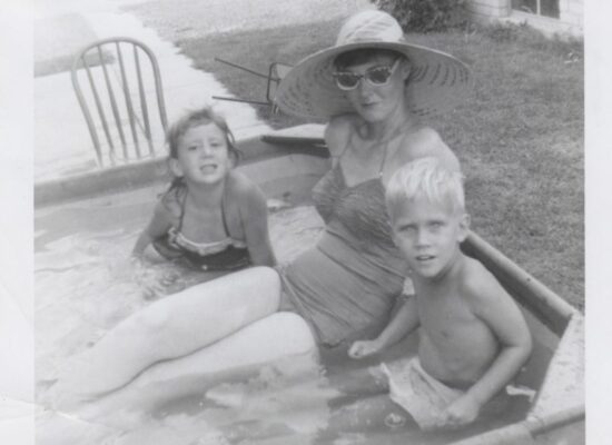 Mom and Tommy, her baby brother, and me in a kiddy pool in our side yard in Detroit, Michigan 1954.