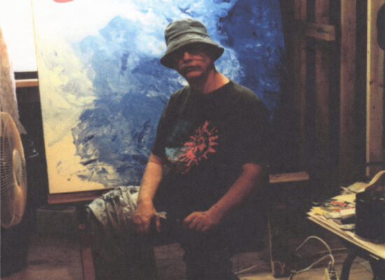 An artist in front of his canvas in progress
