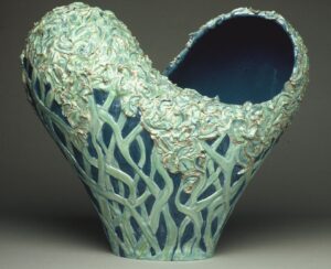 Ceramic heart form cut by infinity symbol with glazed, carved-relief surface