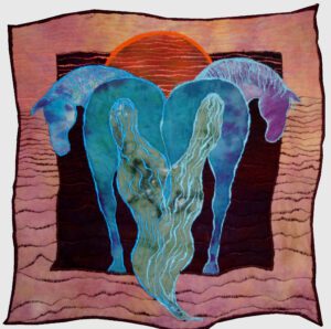 In this Art Quilt, the sun rises over two blue horses from behind, their tails joined to form a heart-like shape, their heads looking back at the viewer.