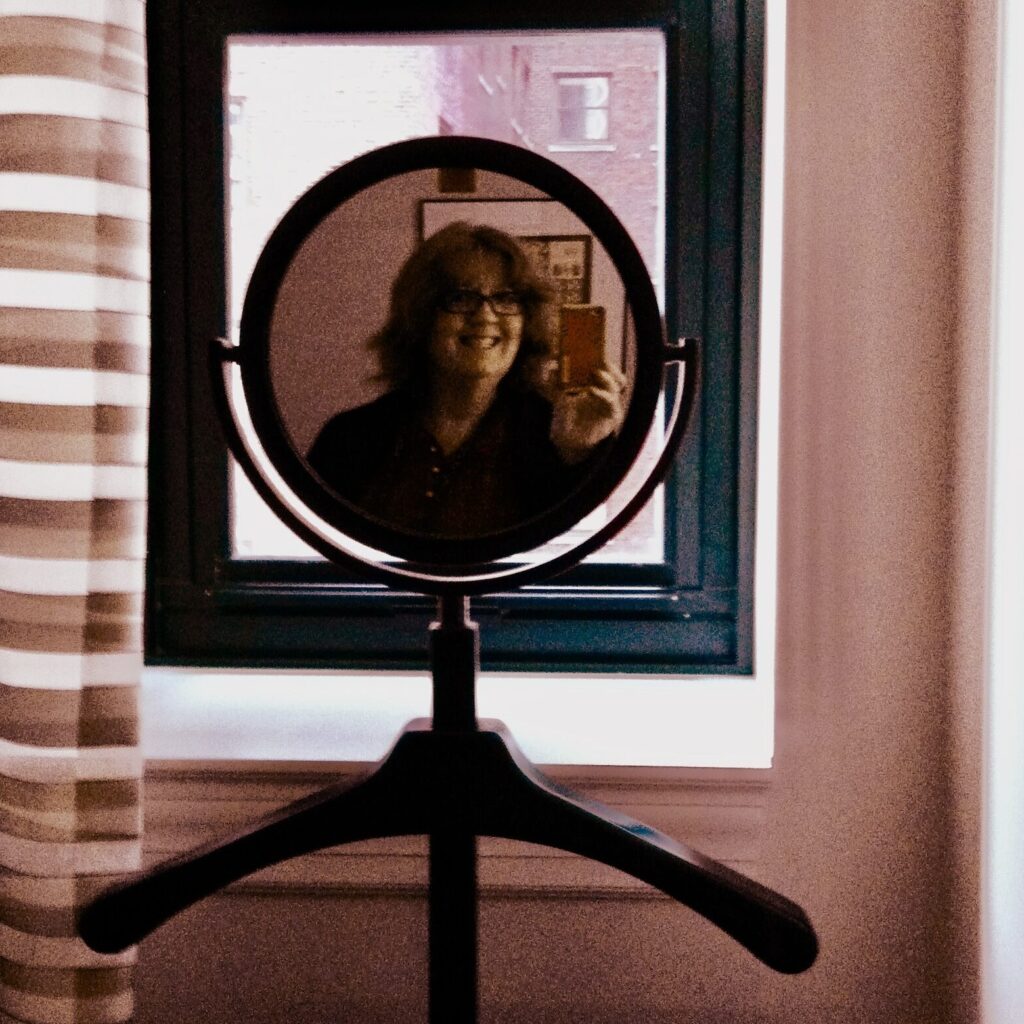 Me in a circular mirror while staying at a Chicago hotel.